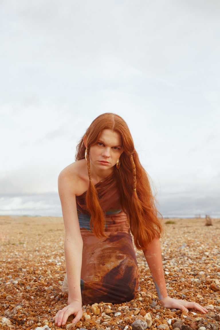 Beautiful model posing in a winter fashion shoot by Brighton seafront.