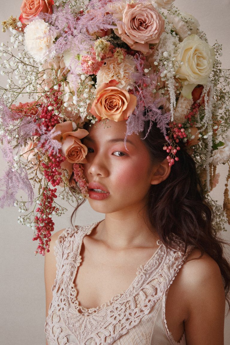 Model wearing a large headpiece made of flowers