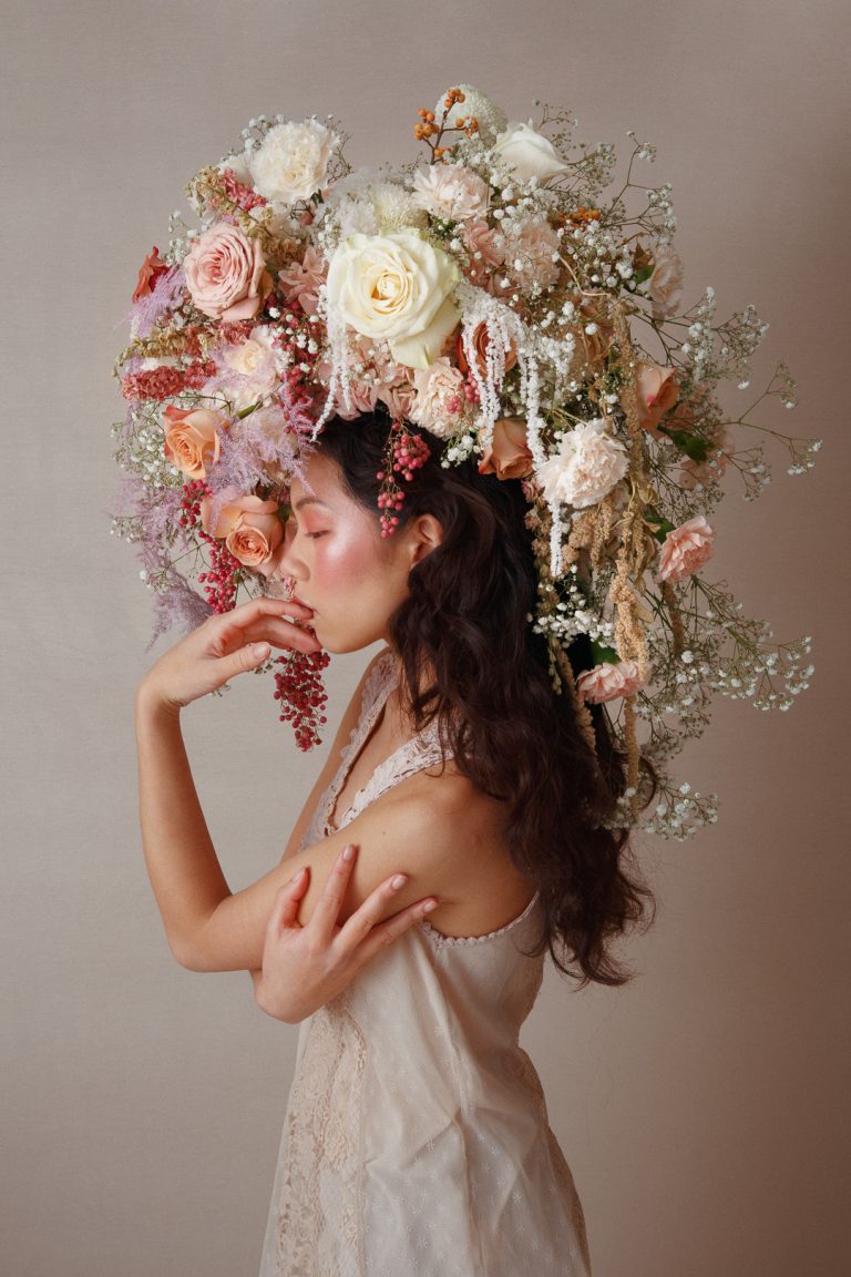 Model wearing a large headpiece made of flowers