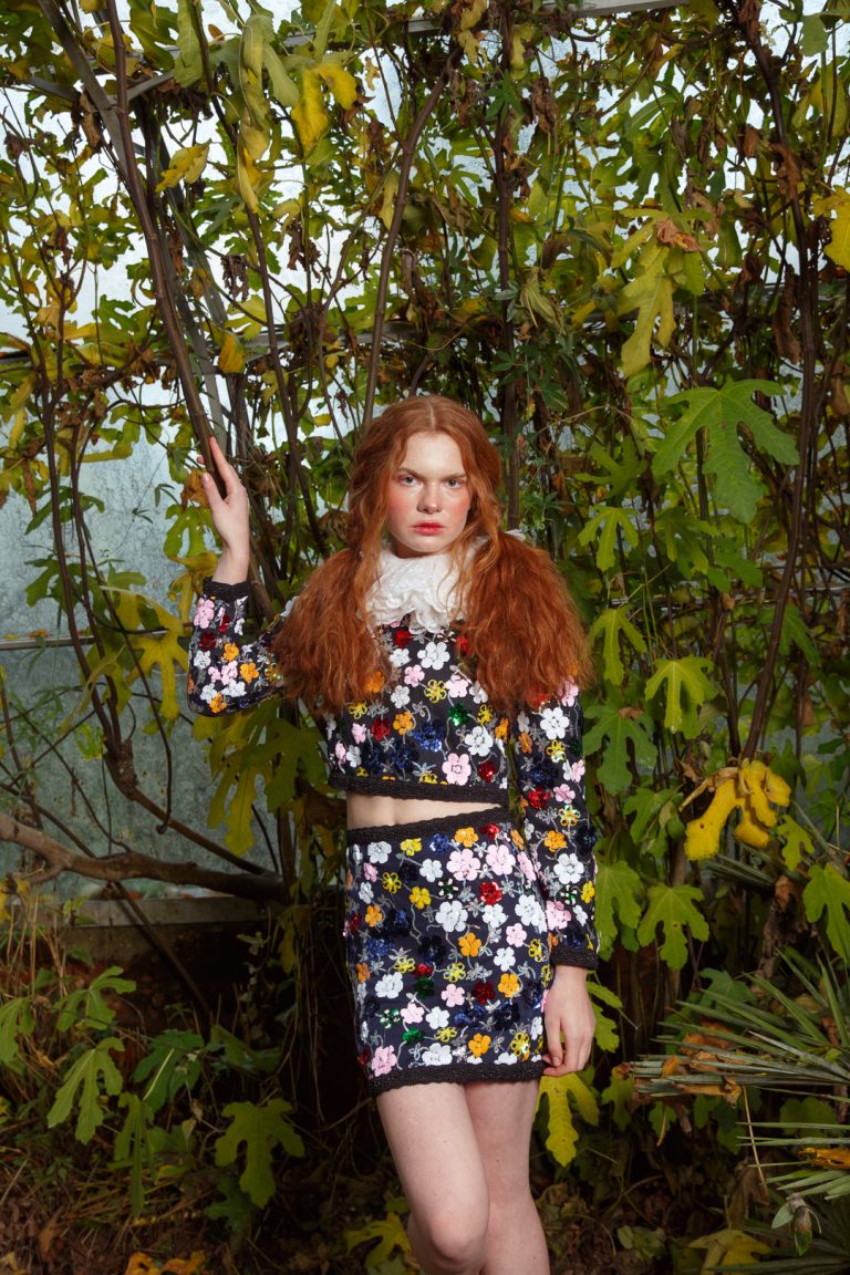 Model wearing flower designer dress in a greenhouse in Brighton.
